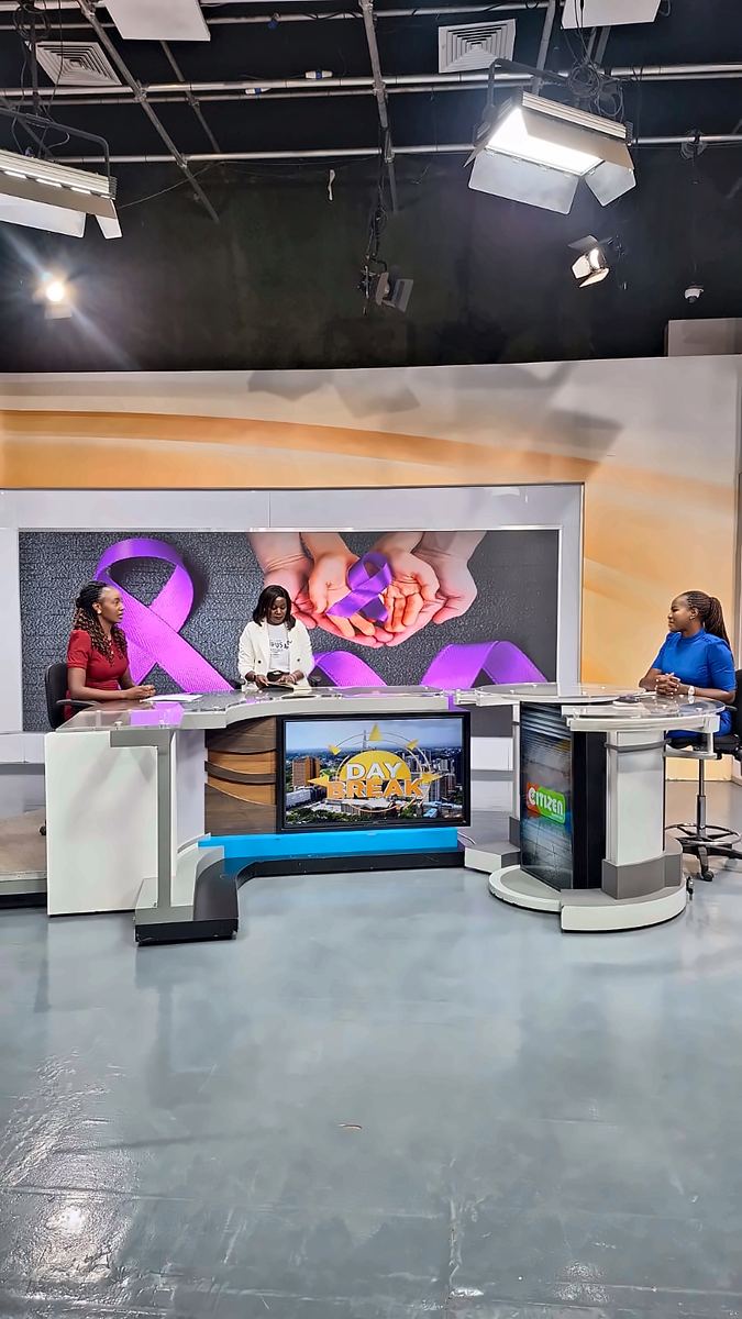 On the set of Citizen TV's Day Break, with a purple lupus ribbon on the screen behind