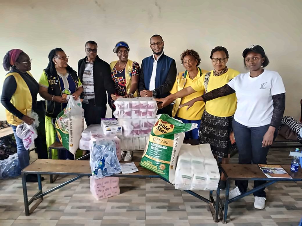 Community members and partners in yellow vests with donated rice, tissue and bottled water