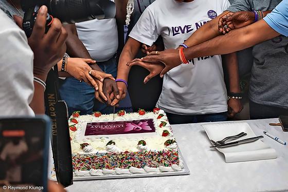 Hands joined together to cut the World Lupus Day cake