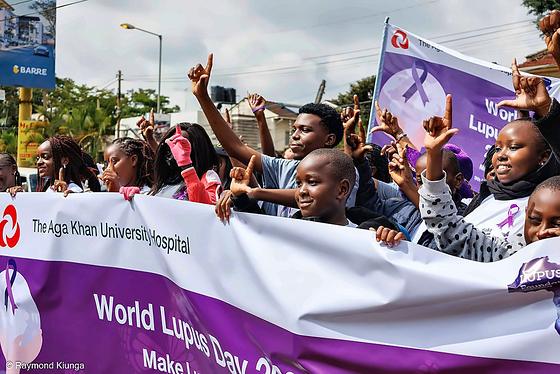 The LFA community raising their hands behind the World Lupus Day 2026 banner in Nairobi