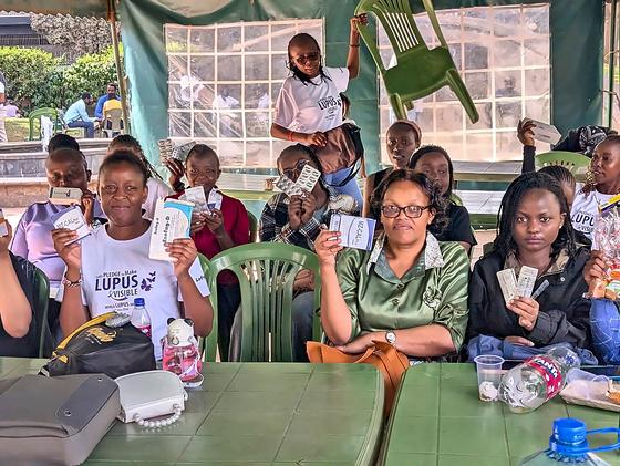 Members holding up cards under the tent at an LFA community meetup